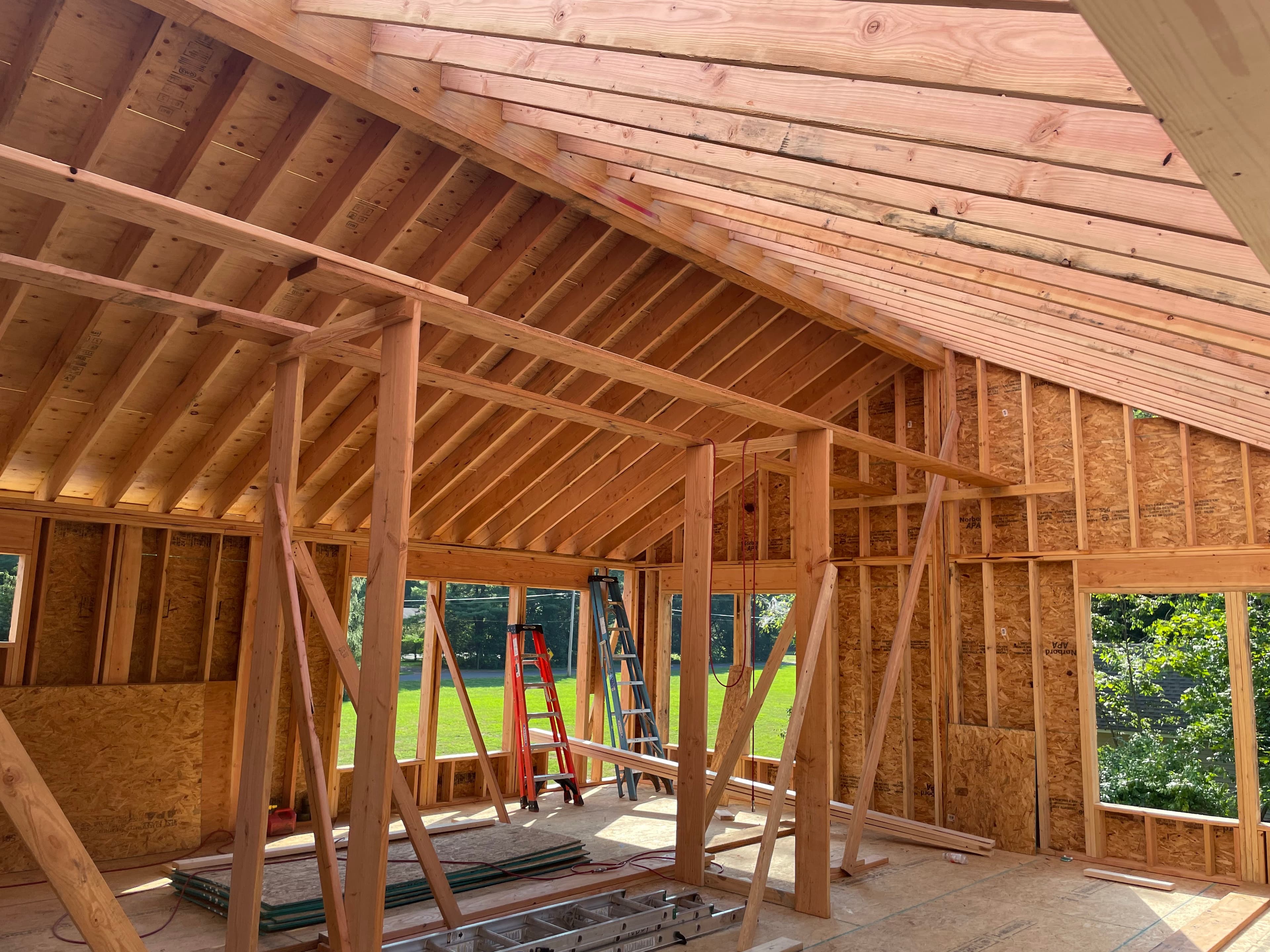 Closer angle of modern custom home showing entry depth, trim returns, and concealed structural steel behind glass spans.